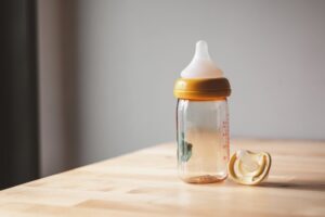 Baby bottle and pacifier sitting on counter